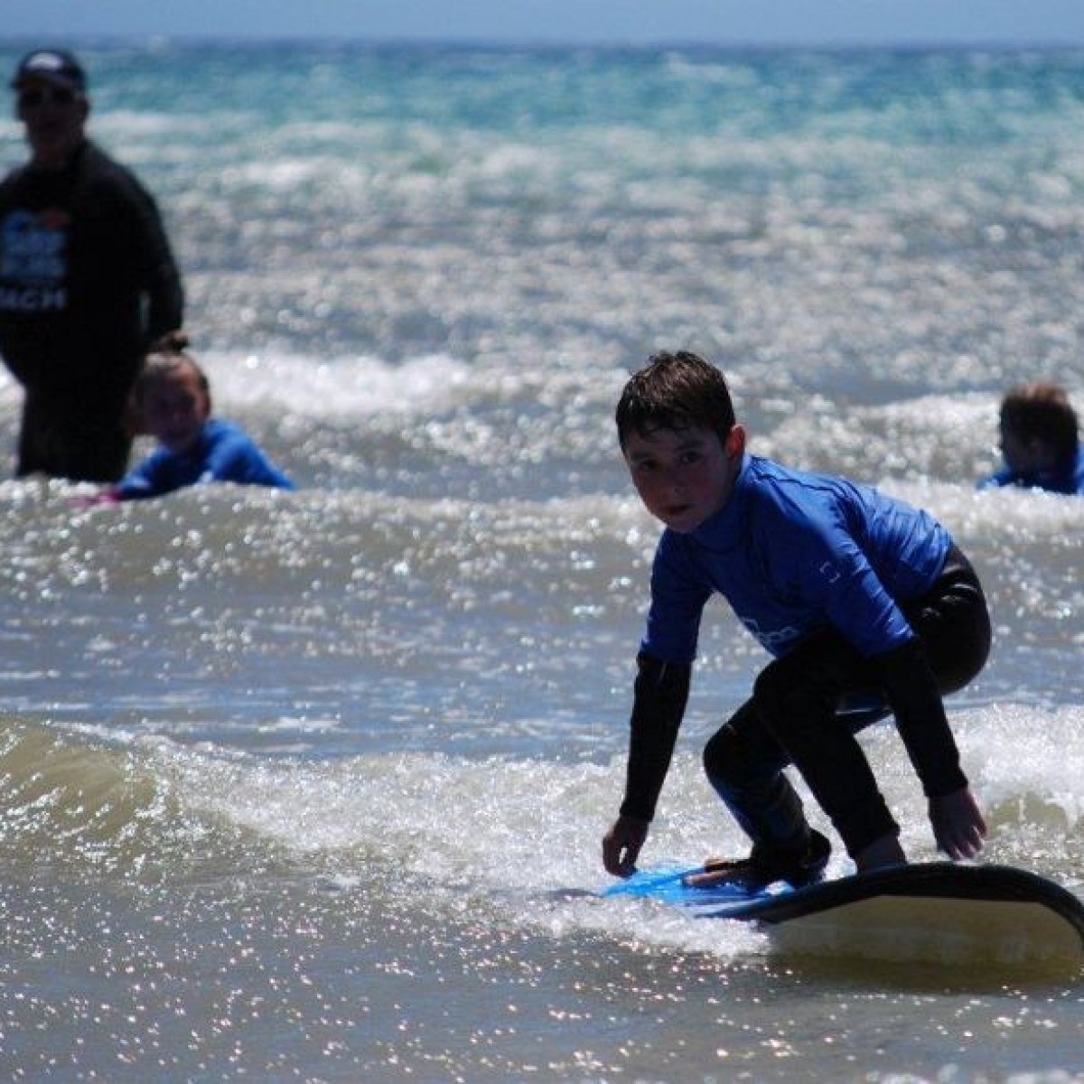 A young surfer getting the hang of riding a wave