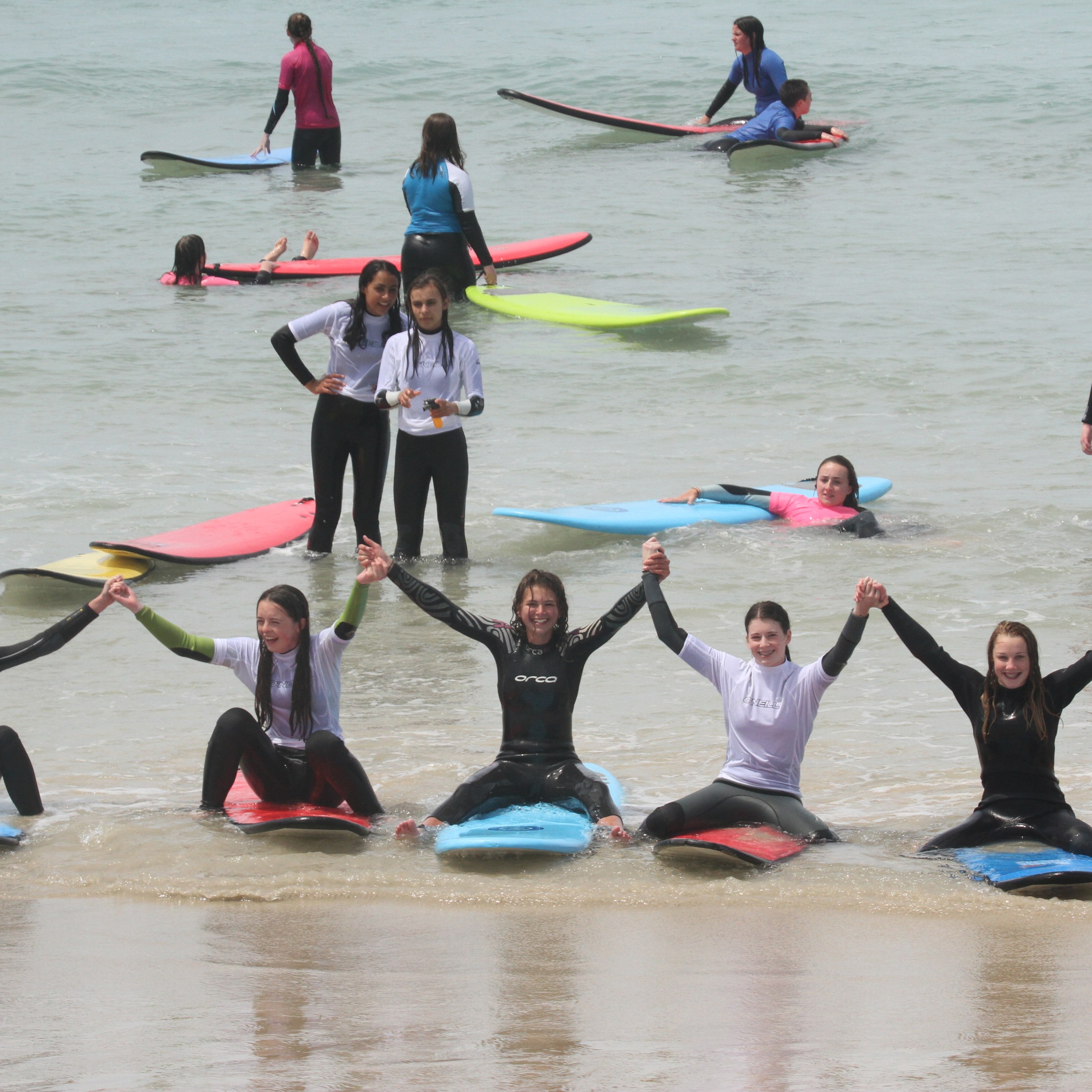 A group of girl surfers posing for a picture